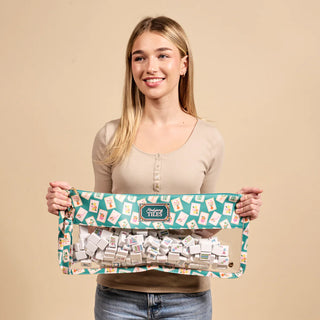 Woman holding a package of game tiles against a beige background