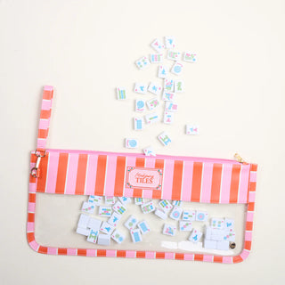 Pink and orange striped pouch with miniature tiles on a light gray background