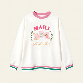White sweatshirt with pink and green accents and 'MAHJ Social Club' text on a beige background
