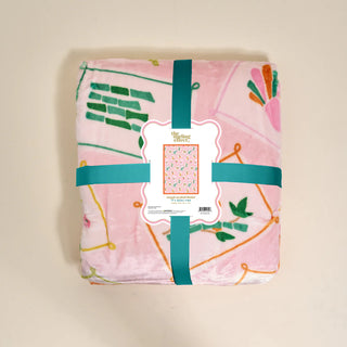 Floral-patterned blanket with a label on a beige background