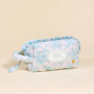 Floral patterned toiletry bag with 'MRS.' patch on a beige background