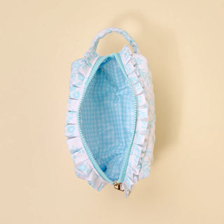 Light blue pouch with ruffled edge on a beige background
