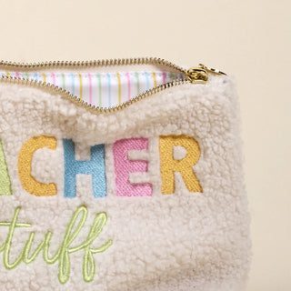 Beige pouch with colorful embroidered text on a beige background