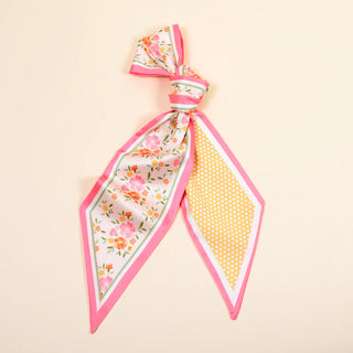 Floral and polka dot fabric bow on a beige background