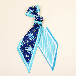 Blue floral and polka dot headband on a beige background