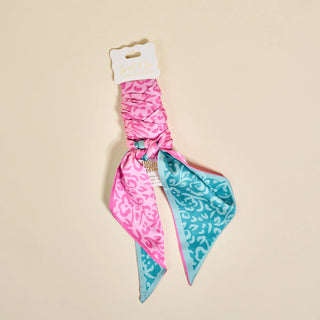 Pink and blue patterned hair scarf on a beige background