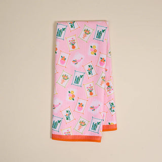 Pink towel with floral and fruit pattern on a beige background