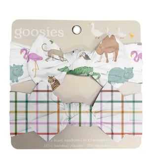A set of three baby hair bows on a cardboard backing labeled 'goosies'. The top bow is white with a colorful animal print (flamingos, crocodile, hippo, camel, cat), the middle bow has a multicolor plaid pattern, and the bottom bow is plain white.