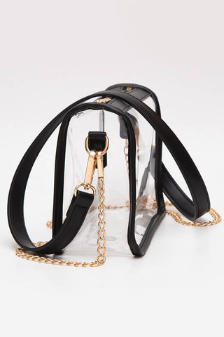 Clear handbag with black straps and gold chain on a white background