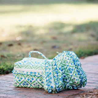 Floral-patterned baby changing bag on a wooden surface with a blurred natural background