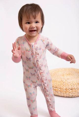Child wearing a pink butterfly-patterned onesie on a white background