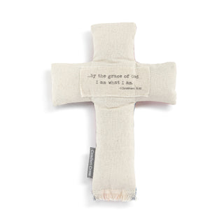 Beige cross-shaped pillow with text on a white background