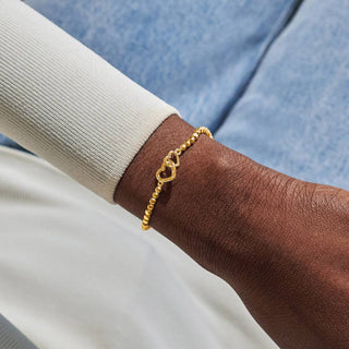 Gold bracelet on a wrist with a blurred background