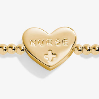 Gold heart-shaped charm with 'NURSE' and a cross on a white background