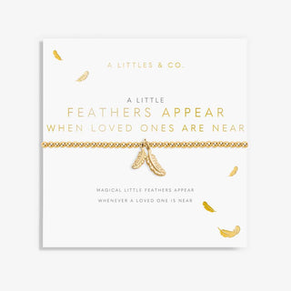 Gold bracelet with feather charms on a card from A Littles & Co.