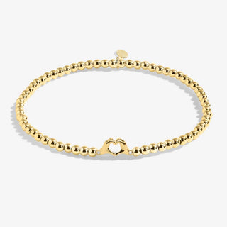 Gold bracelet on a light gray background