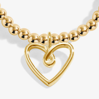 Gold necklace with a heart-shaped clasp on a white background