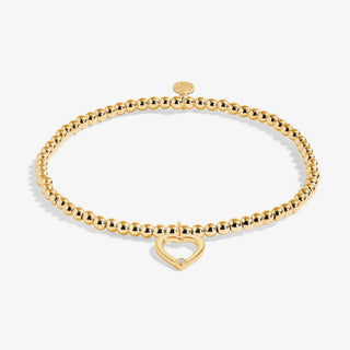 Gold bracelet with a heart-shaped clasp on a white background