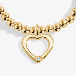 Gold necklace with a heart-shaped clasp on a white background