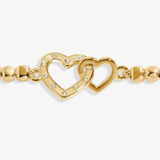 Gold bracelet with heart designs on a white background