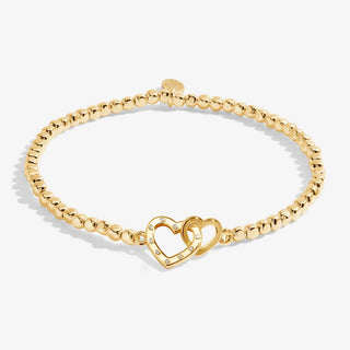 Gold bracelet with interlocking heart charms on a white background