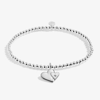 Silver bracelet with a heart-shaped charm on a white background