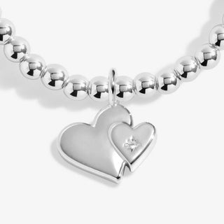Silver beaded bracelet with a heart-shaped charm on a white background