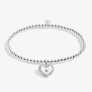 Silver bracelet with a heart-shaped charm on a white background