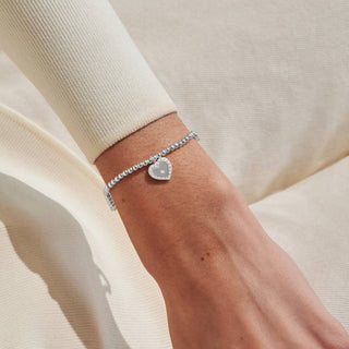 Silver bracelet on a wrist with a neutral background