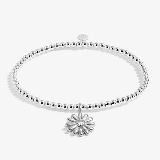 Silver bracelet with a daisy charm on a white background
