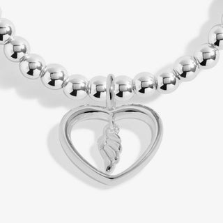 Silver beaded bracelet with a heart-shaped clasp and wing charm on a white background