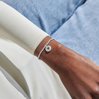 Silver bracelet on a wrist with a blurred background