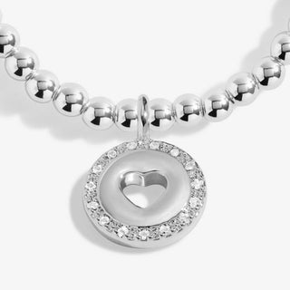 Silver beaded bracelet with a heart-shaped charm on a white background