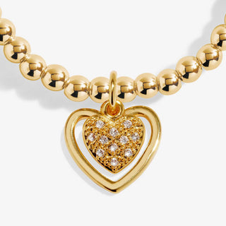 Gold necklace with a heart-shaped pendant on a white background