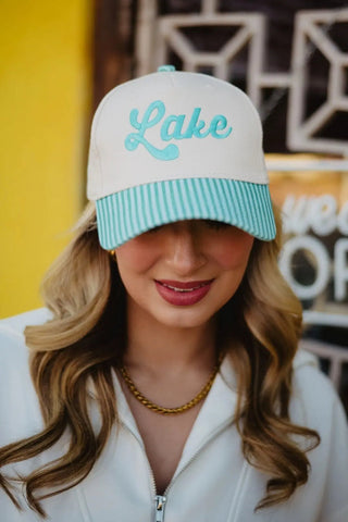 Person wearing a cap with 'Lake' text against a yellow wall.
