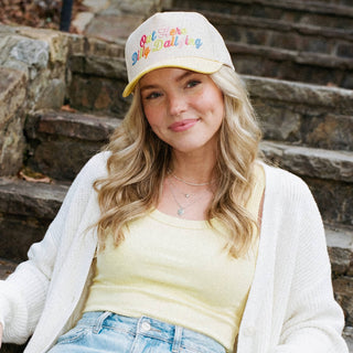 Woman wearing a colorful cap sitting on stone steps