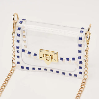 White handbag with gold chain and blue accents on a light gray background
