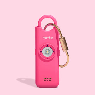 Pink electronic device with gold carabiner on a pink background