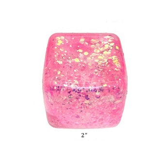 Pink cube with glittery specks on a white background