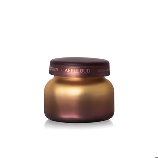A small cosmetic jar with a metallic gradient finish shifting from gold to deep plum, featuring a matching dark plum screw cap. The cap has white text that reads 'matsuman • APPLE OUD • 226 g bouclé'.