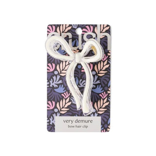 Bow hair clip on a patterned card with 'very demure' branding