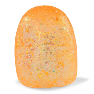 An orange textured dome-shaped item, possibly a decorative stone, ornament, or egg-shaped container, filled with shimmering gold, silver, and multicolored glitter, shown on a white background.