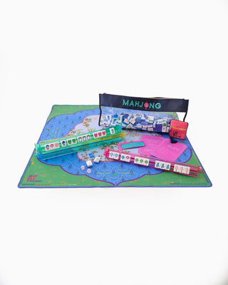 Mahjong game set with tiles, dice, and instructions on a green mat with a map design.