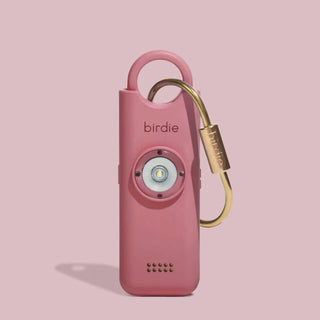 Pink device with a gold carabiner on a pink background