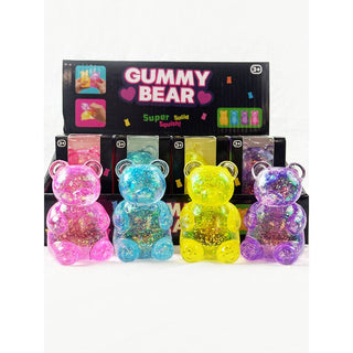 Four translucent gummy bear squishies filled with glitter in pink, blue, yellow, and purple, displayed in front of a black retail box labeled 'GUMMY BEAR Super Solid Squishy'.