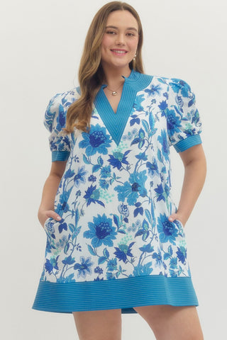 Woman wearing a blue floral dress on a white background
