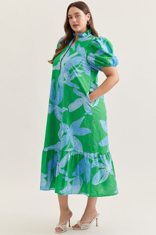 Woman wearing a green and blue floral dress on a white background