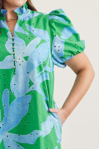 Green and blue floral dress with puff sleeves on a neutral background