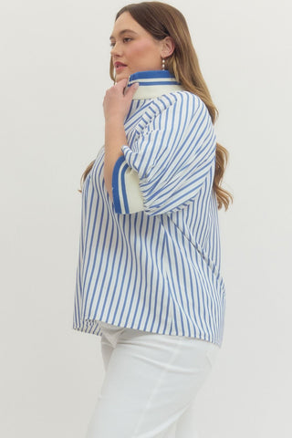 Woman wearing a blue and white striped shirt with a plain background