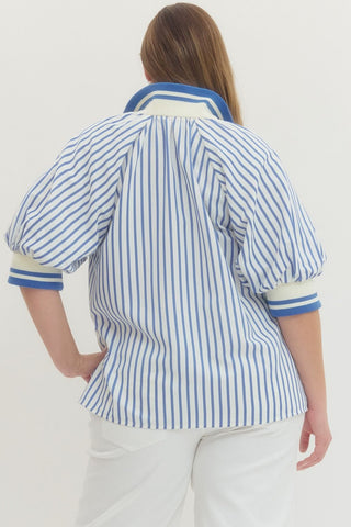 Person wearing a blue and white striped shirt with a plain background